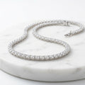 WCJ 925 Sterling Silver Moissanite Tennis Necklace flat lay on marble surface